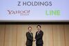 Kentaro Kawabe, president and chief executive officer of Z Holdings Corp., formerly known as Yahoo Japan, left, and Takeshi Idezawa, chief executive officer of Line Corp., shake hands as they pose for a photograph during a news conference in Tokyo.