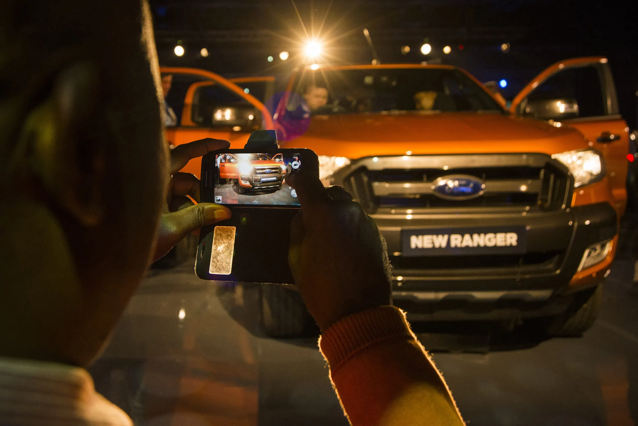 A visitor uses a mobile phone to photograph the new Ford Ranger pickup truck on display at the Ford Motor Co. 'Go Further' event at the Sandton Convention Center in Johannesburg, South Africa, on Tuesday, Aug. 11, 2015. Ford reported net income of $1.9 billion, or 47 cents a share, compared with $1.3 billion, or 32 cents per share a year earlier.

