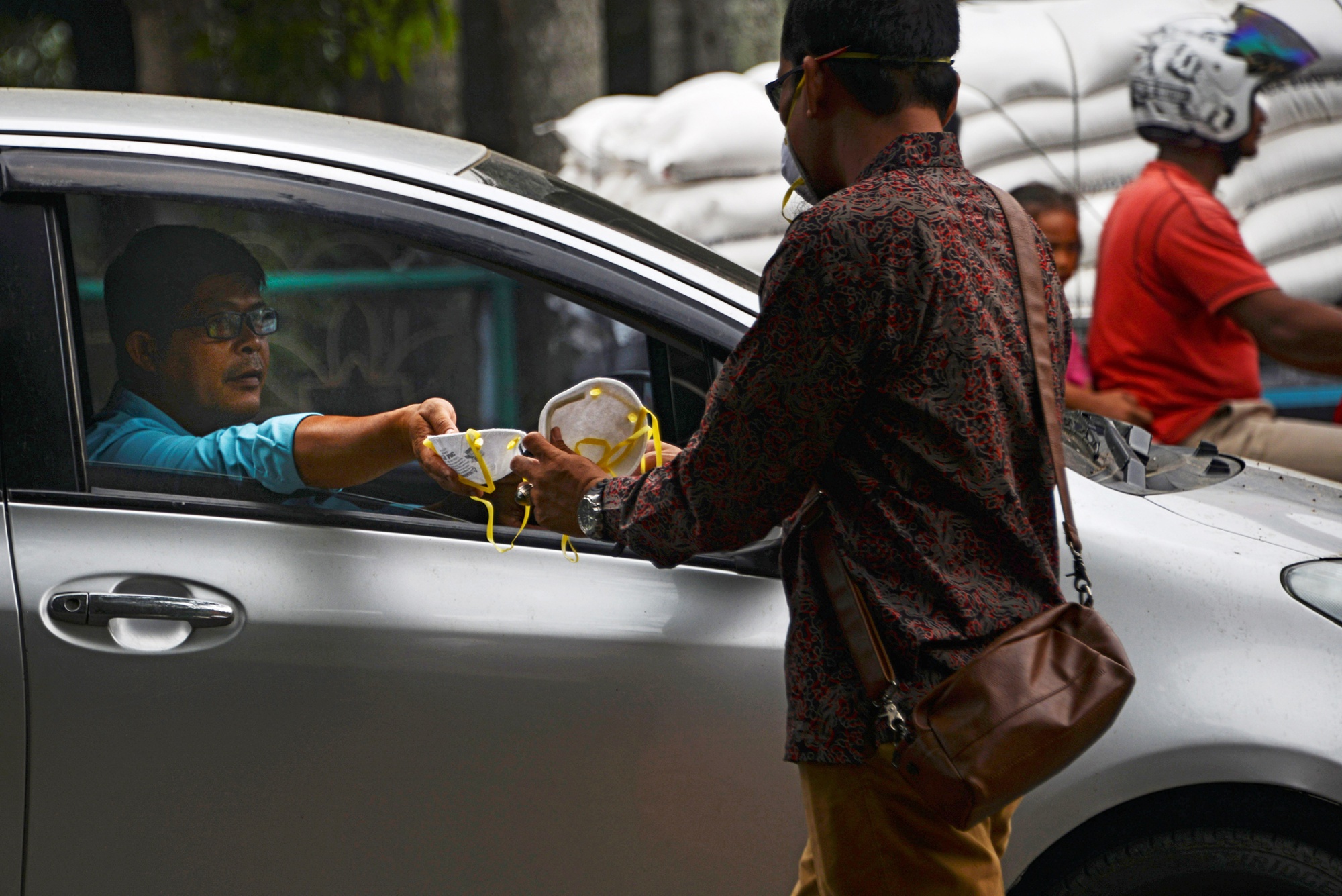 Motorists share facemasks in Banda Aceh, Indonesia, on Sept. 24.