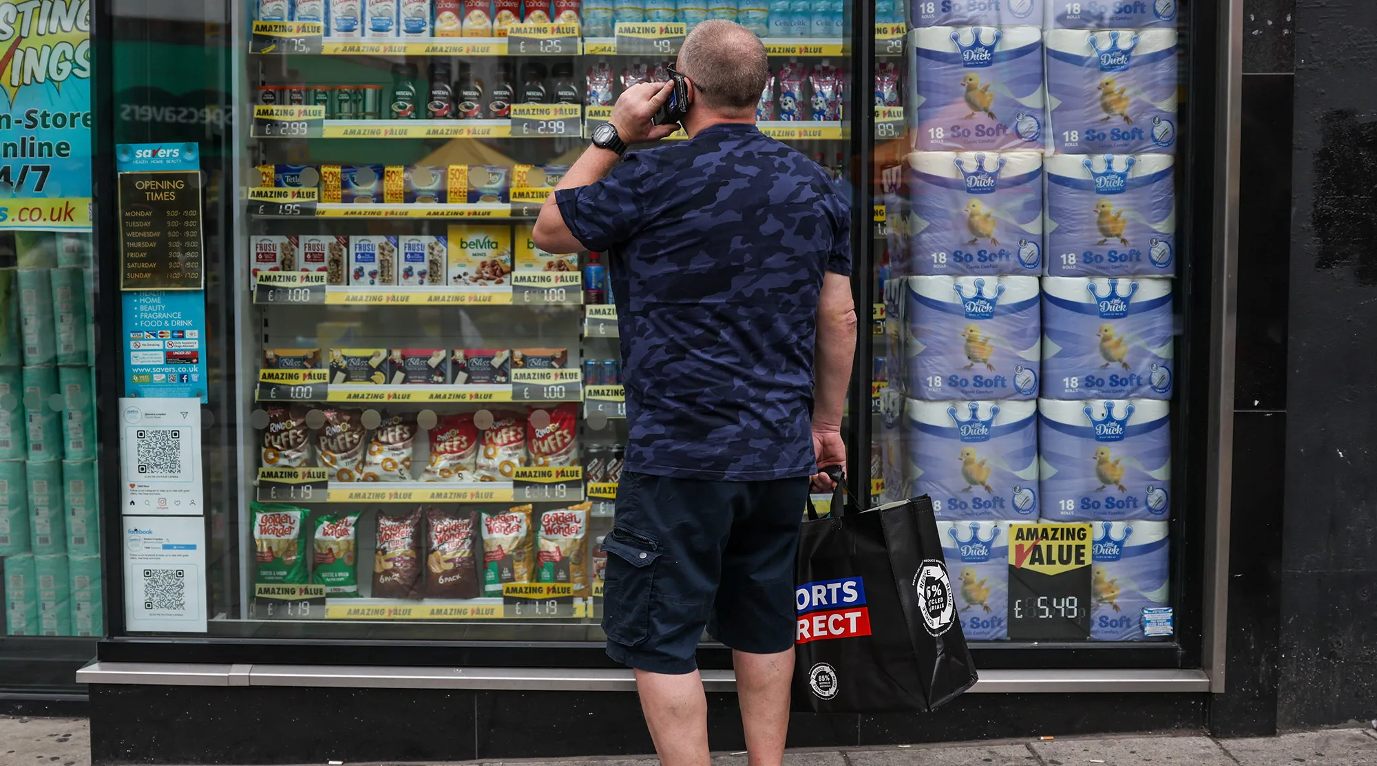 A pedestrian looks in&nbsp;the window display of a discount shop in Croydon, UK.