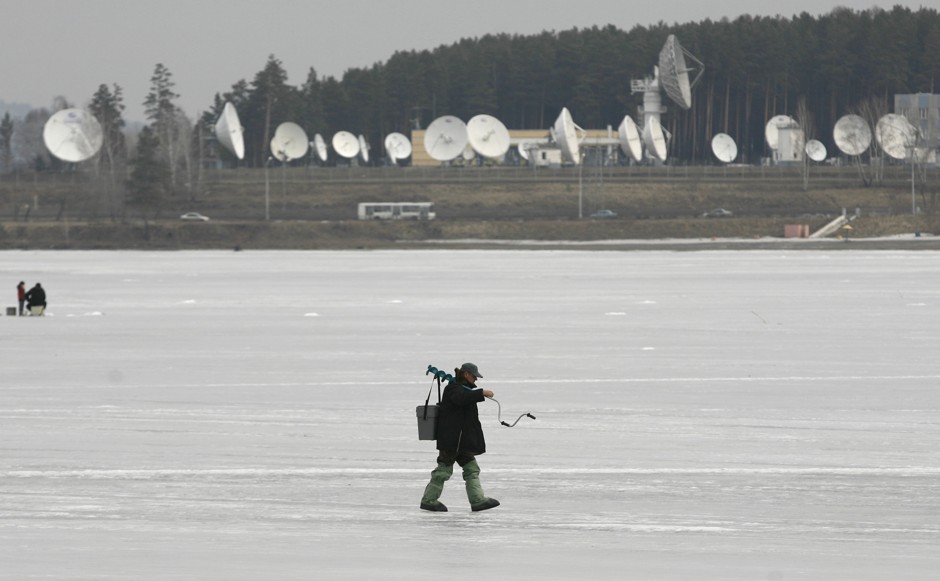  A fisherman walks on the frozen surface of a lake in Zheleznogorsk, Russia, with satellite dishes of a local space-communication center in the background. The town produced plutonium in Soviet times and is now a closed community.