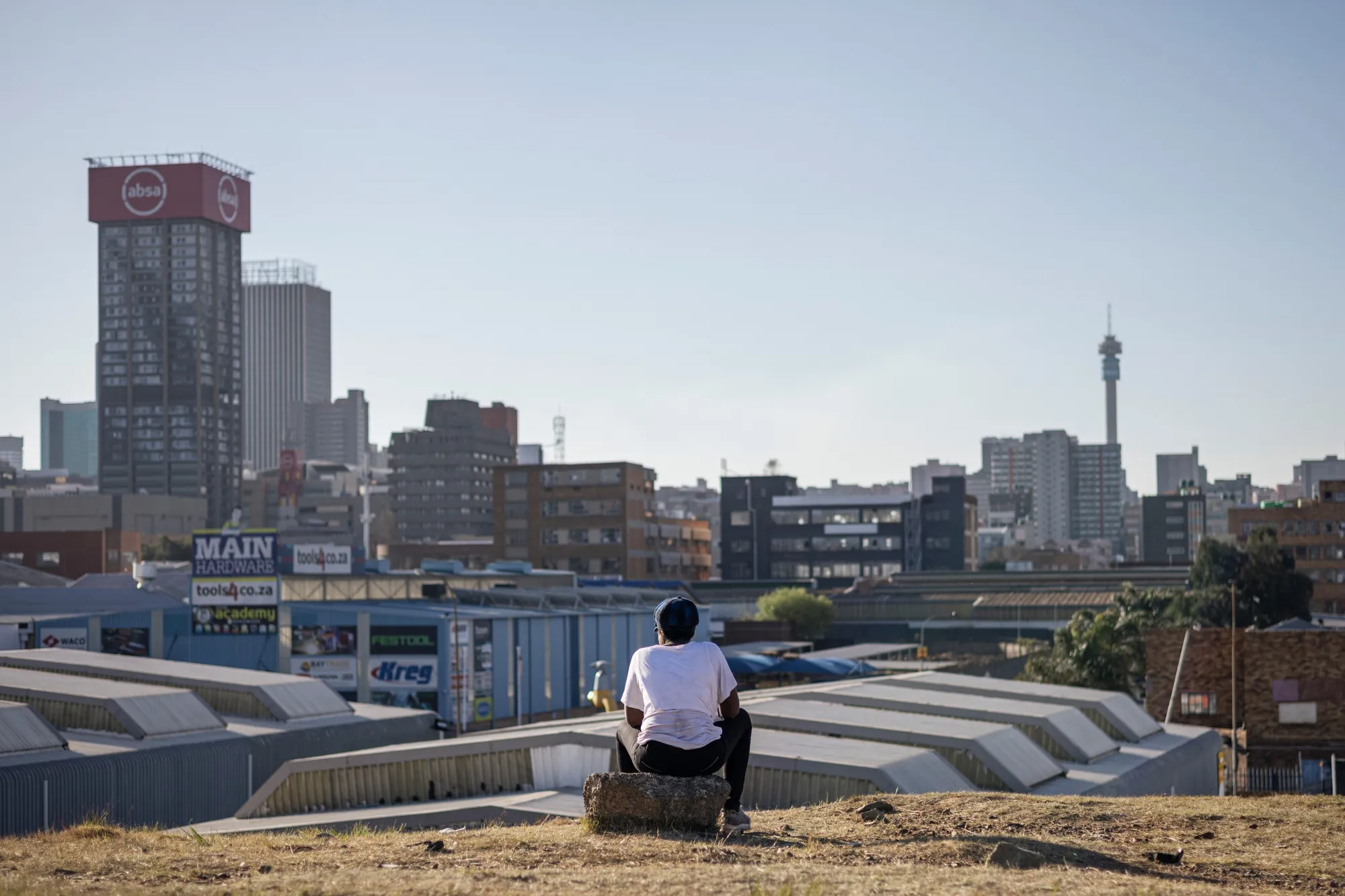 A resident looks out towards the skyline of the central business district in Johannesburg.