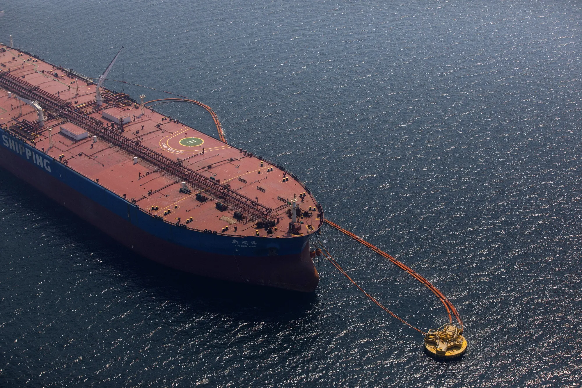 Pipes feed oil onto a&nbsp;tanker near Saudi Aramco's Ras Tanura refinery.