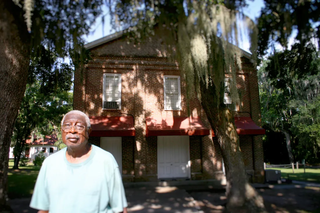 Acie Johnson is a legal client of the Center for Heirs’ Property Preservation. The Center cleared his title (from Heirs’ Property) and put his house in order. Johnson was able to refinance his loan and settle the future of his house in his will. He stands in front of his church, the Brick Baptist Church on St. Helena Island, S.C.
