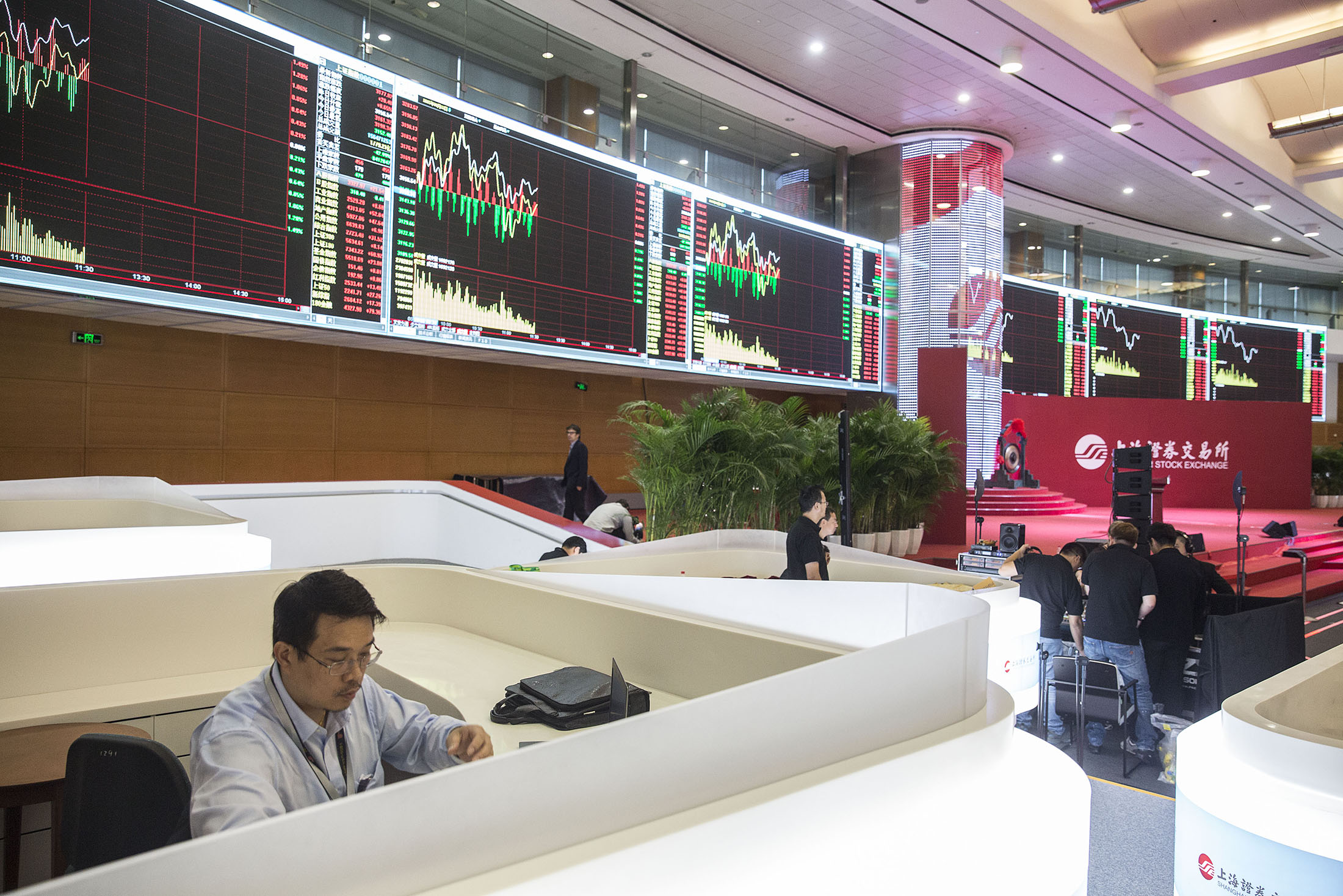 A man sits in front of electronic boards at the Shanghai Stock Exchange in Shanghai, China, on Tuesday, Sept. 22, 2015. U.K. Chancellor of the Exchequer George Osborne is seeking to strengthen Britain's ties with China, including a possible stock-exchange link, as he underlines the country's value as an investment partner in spite of recent market shocks.
