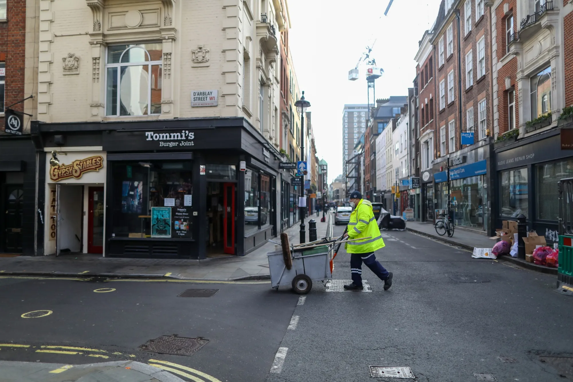 A municipal worker cleans the street in the Soho district of London, U.K., on Thursday, Nov. 5, 2020. The Bank of England boosted its bond-buying program by a bigger-than-expected 150 billion pounds ($195 billion) in another round of stimulus to help the economy through a second wave of coronavirus restrictions.
