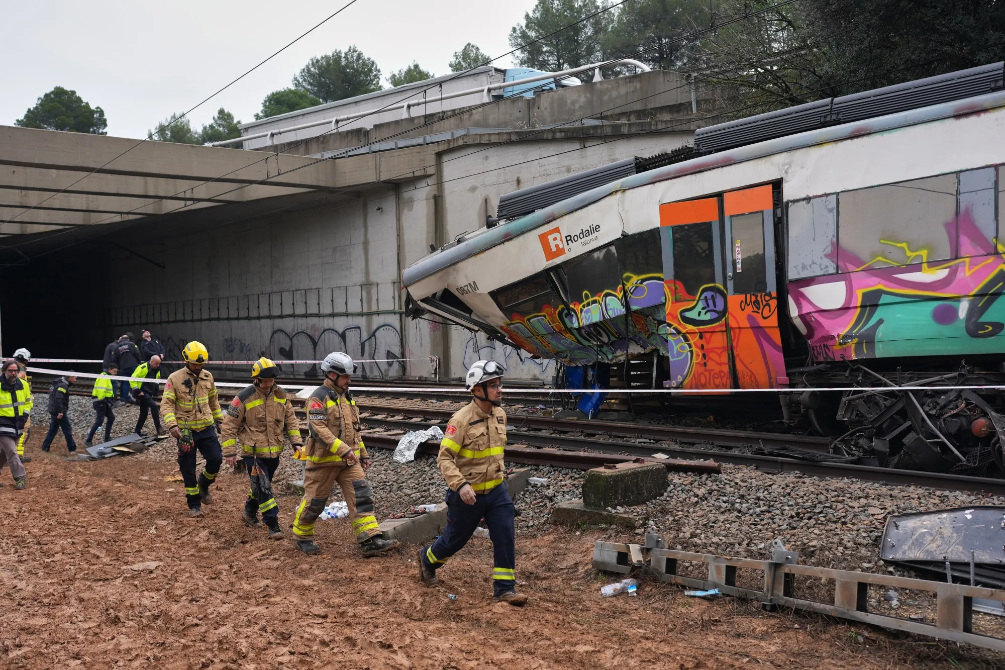 Police officers and firefighters inspect damage following a train crash near Barcelona, on Jan. 21.