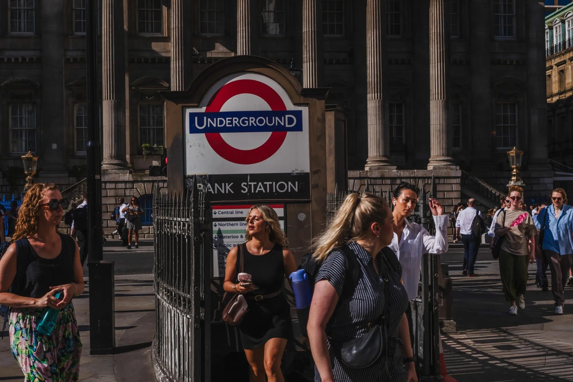 City workers exit Bank Underground station at rush hour during a heat wave.