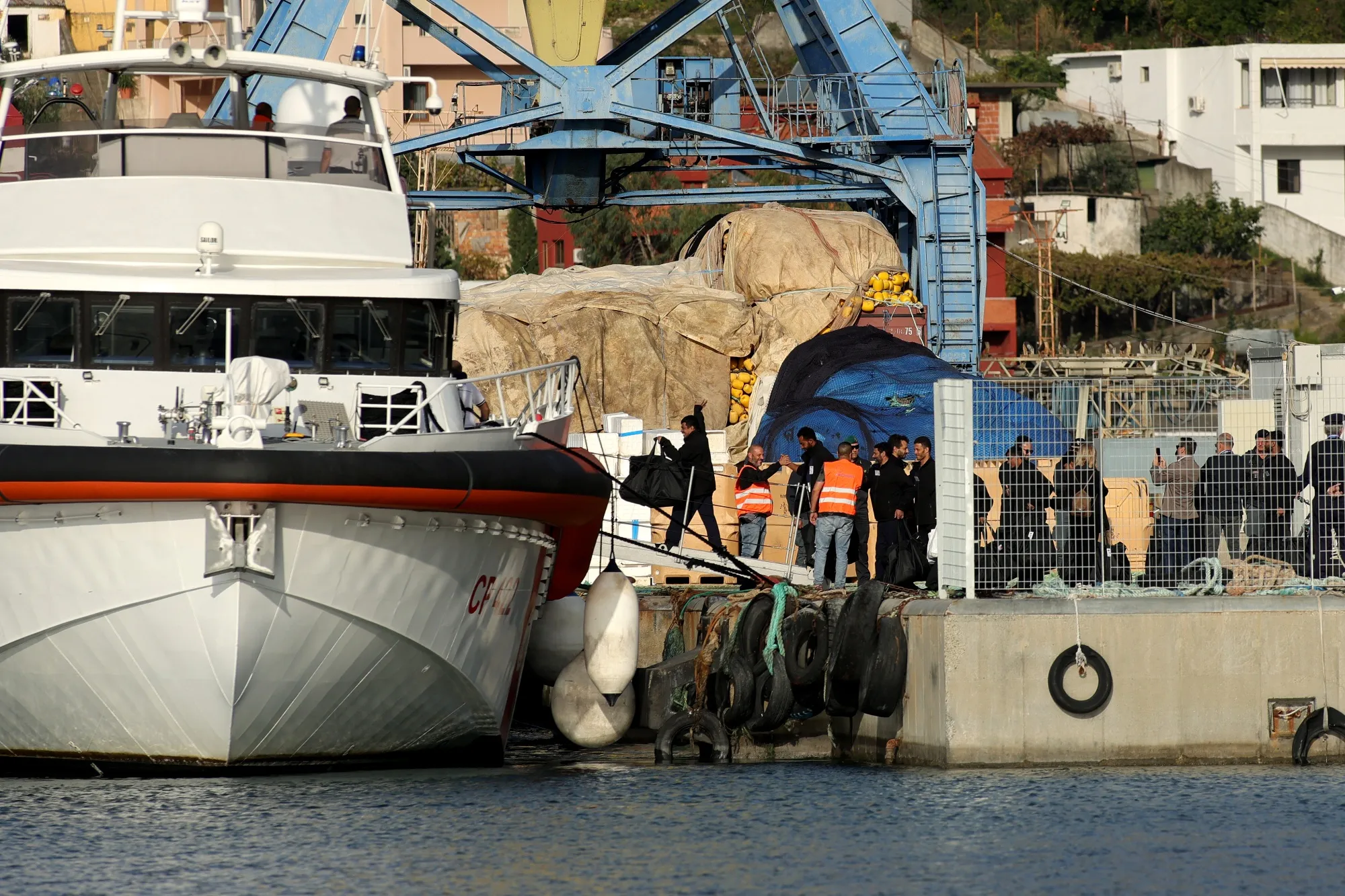 A group of migrants board&nbsp;an Italian coast guard ship at Shengjin port in Albania.