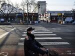 A cyclist passes through a quiet street&nbsp; in Beijing on Feb. 19.