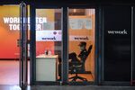 A security guard sits in the entrance to a WeWork office in Beijing on August 12, 2020.