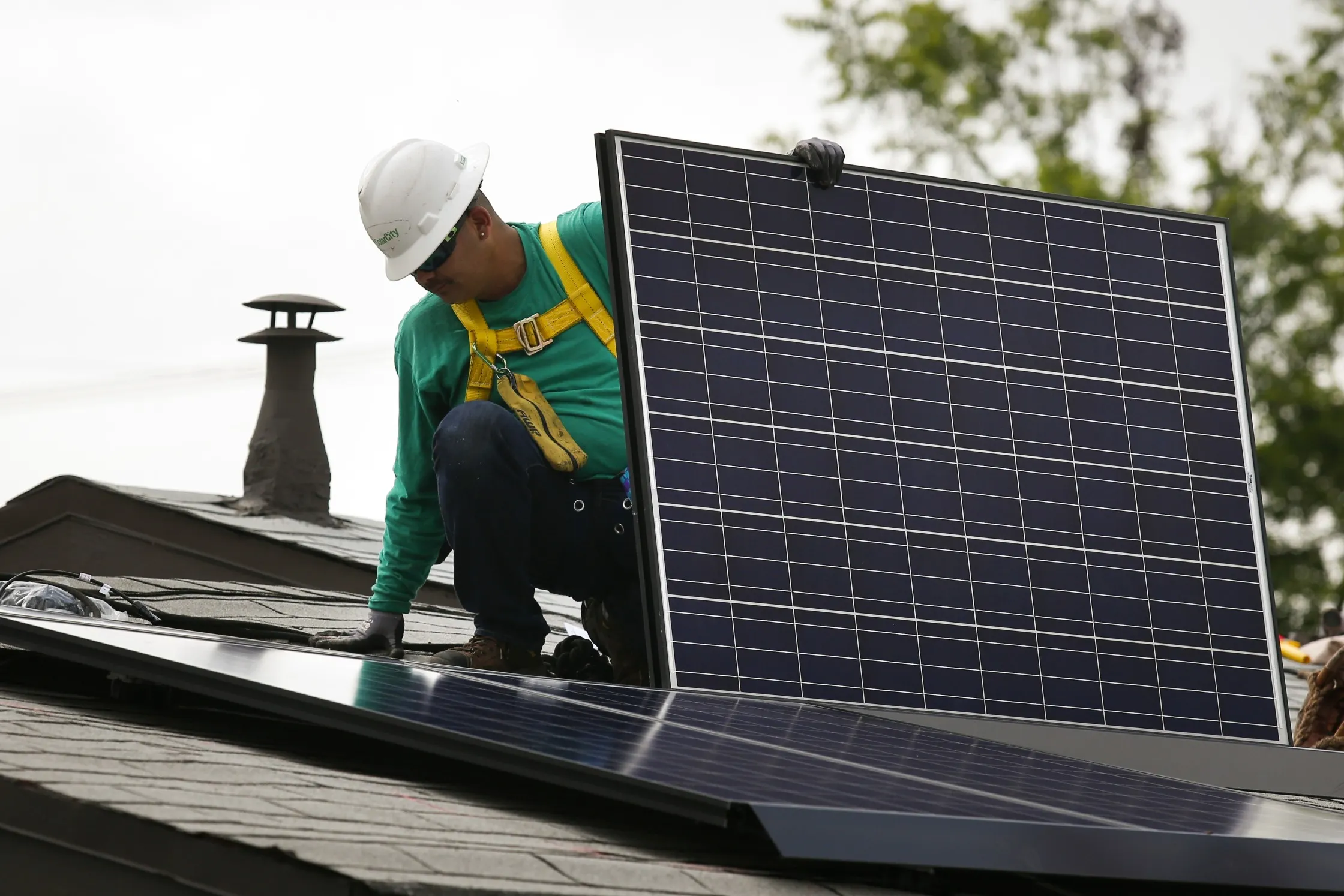 An employee installs a solar panel on the roof of a home in Los Angeles, California in&nbsp;2014.