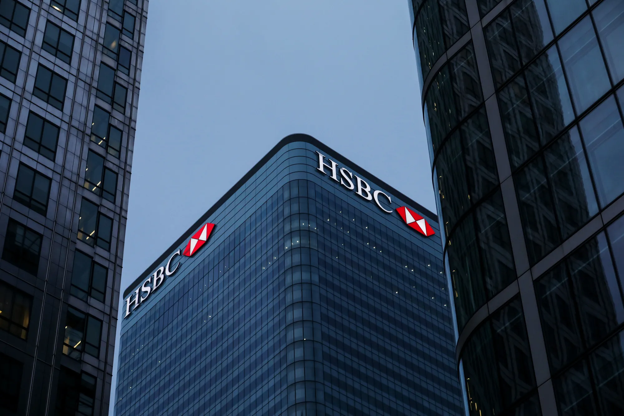 Logos sit illuminated on the HSBC Holdings Plc headquarter skyscraper offices in the Canary Wharf business, financial and shopping district in London.