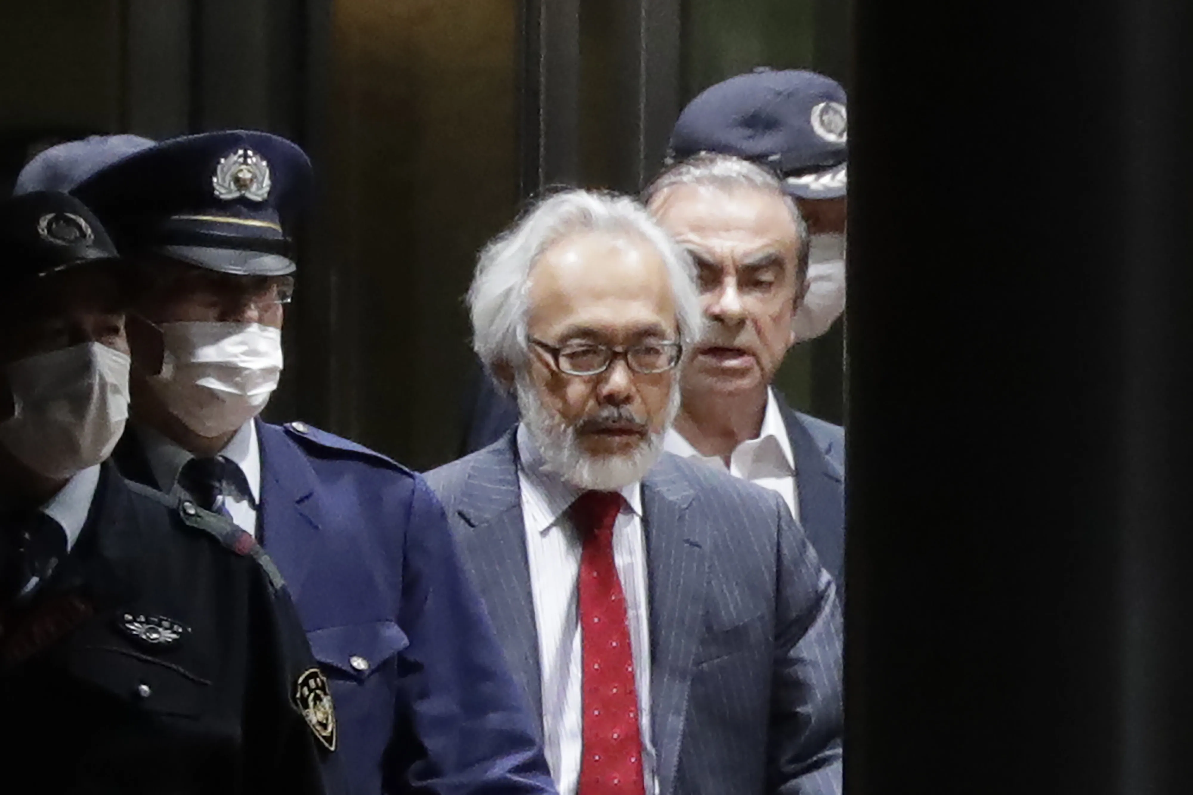 Takashi Takano, center, and Carlos Ghosn,&nbsp;right, exit the Tokyo Detention House in Tokyo, Japan, on Thursday, April 25, 2019.