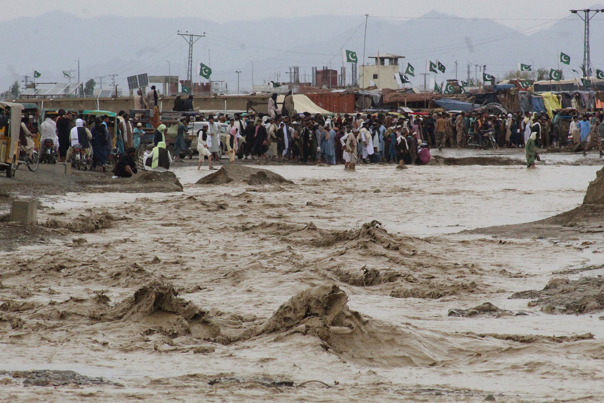 People wade through flood waters after a heavy monsoon in the border town of Chaman, Pakistan, on Aug. 25.