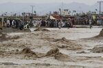 People wade through flood waters after a heavy monsoon in the border town of Chaman, Pakistan, on Aug. 25.