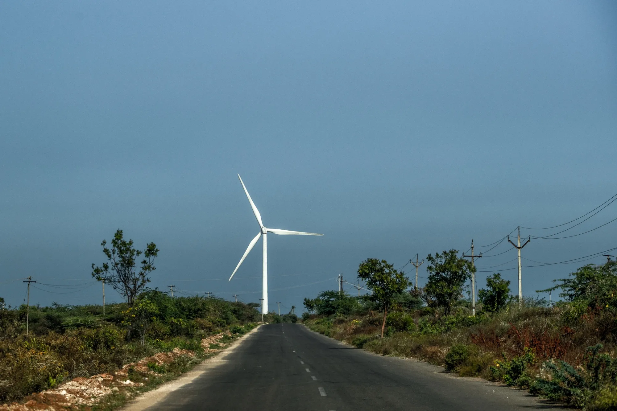 A wind turbine near a highway in India, a country facing the prospect of lower wind speeds and reduced solar irradiance