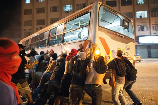 Demonstrators overturn a bus late on June 19 near Rio de Janeiro