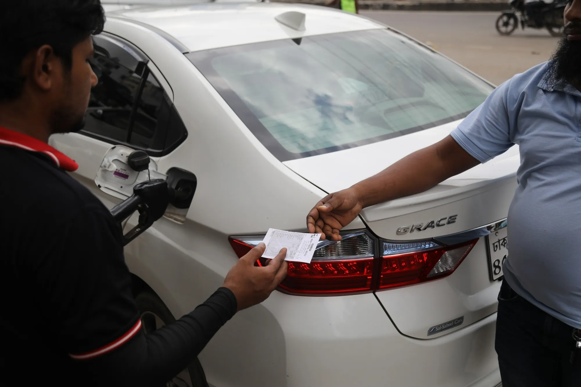 A gas station clerk gives a receipt to a customer in Dhaka, on&nbsp;Aug. 9.&nbsp;