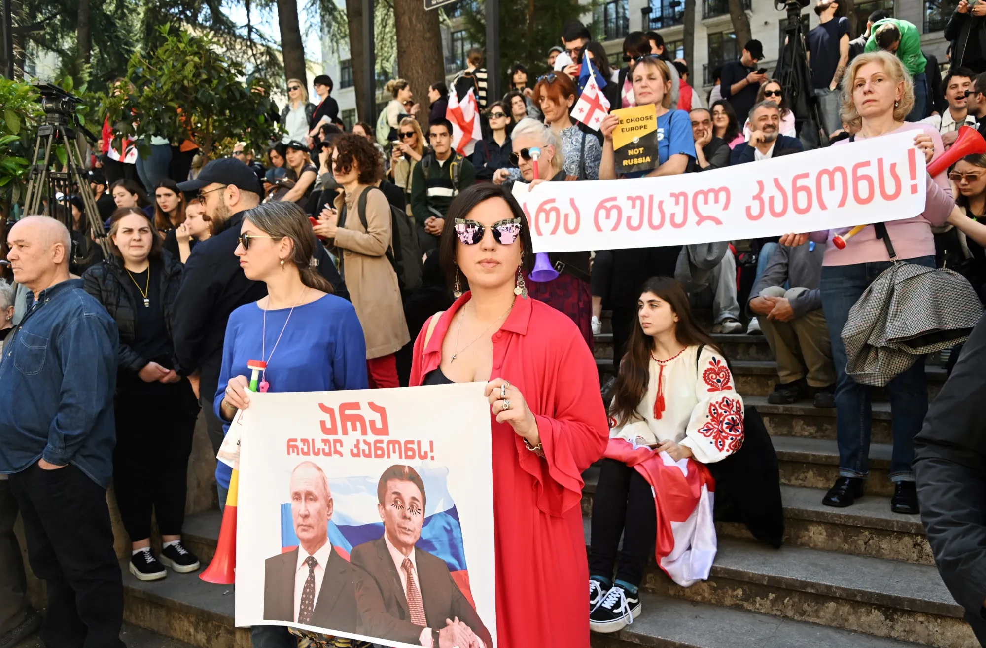 A protester holds a banner depicting Russian president Vladimir Putin and Georgian businessman and former Prime Minister, Bidzina Ivanishvili in Tbilisi last month.