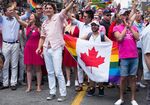Canadian Prime Minister Justin Trudeau marches in the annual Pride Festival parade with Syrian refugee Bassel Mcleash, holding flag, in Toronto, on July 3, 2016.
