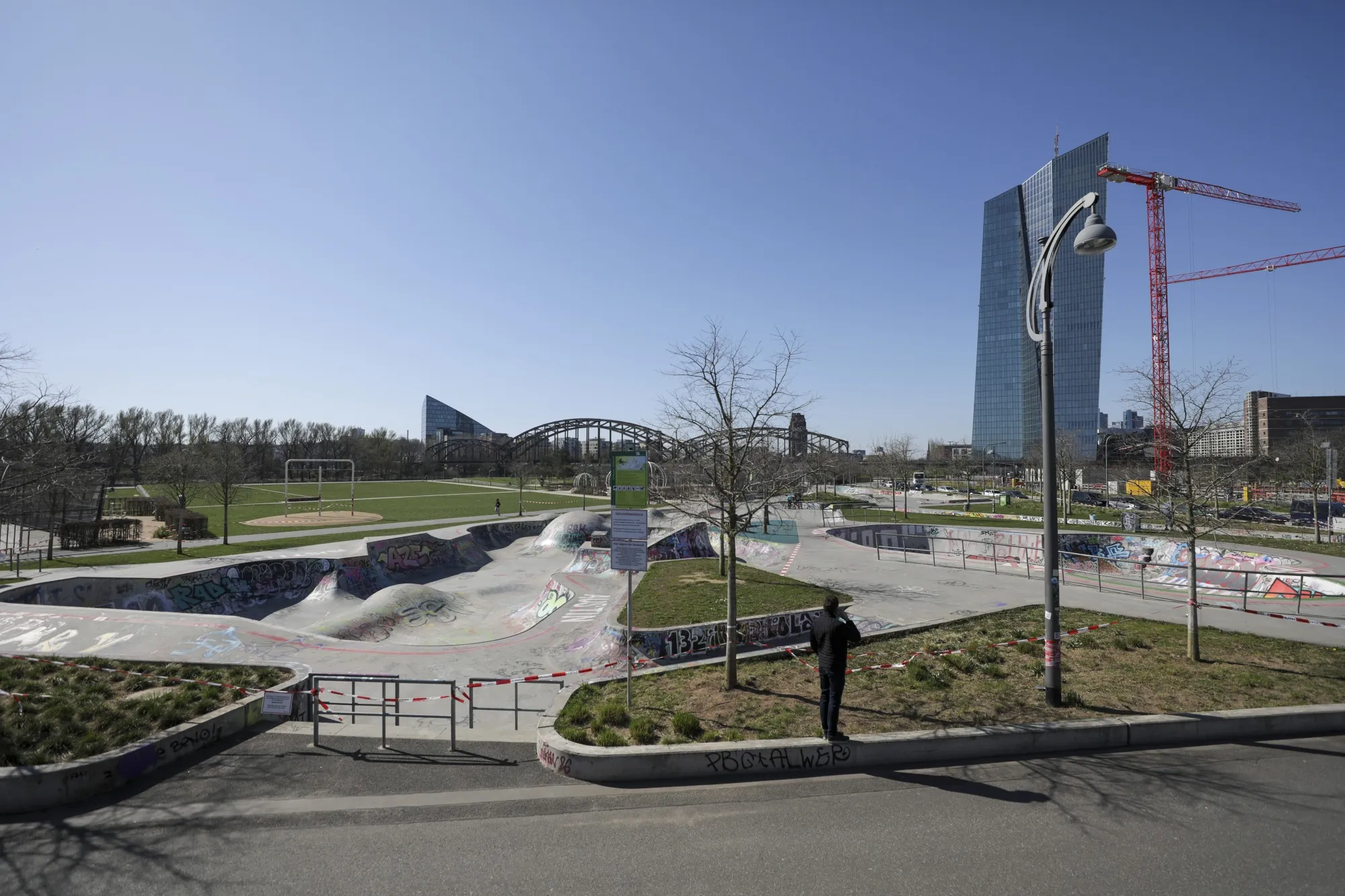 A pedestrian stands near an empty skate park near the European Central Bank headquarters in Frankfurt.