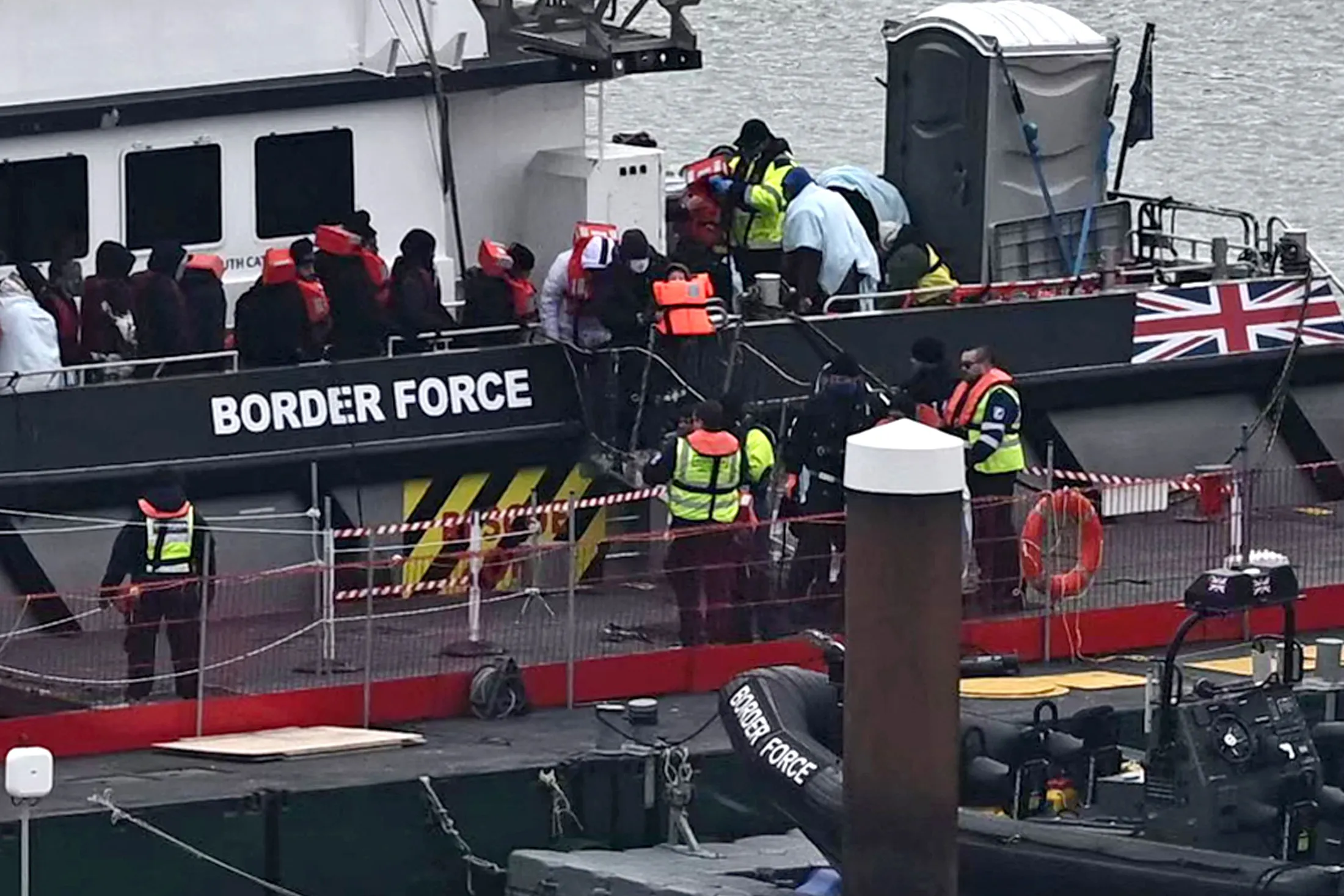 Migrants are escorted ashore from a UK Border Force vessel in Dover, UK.
