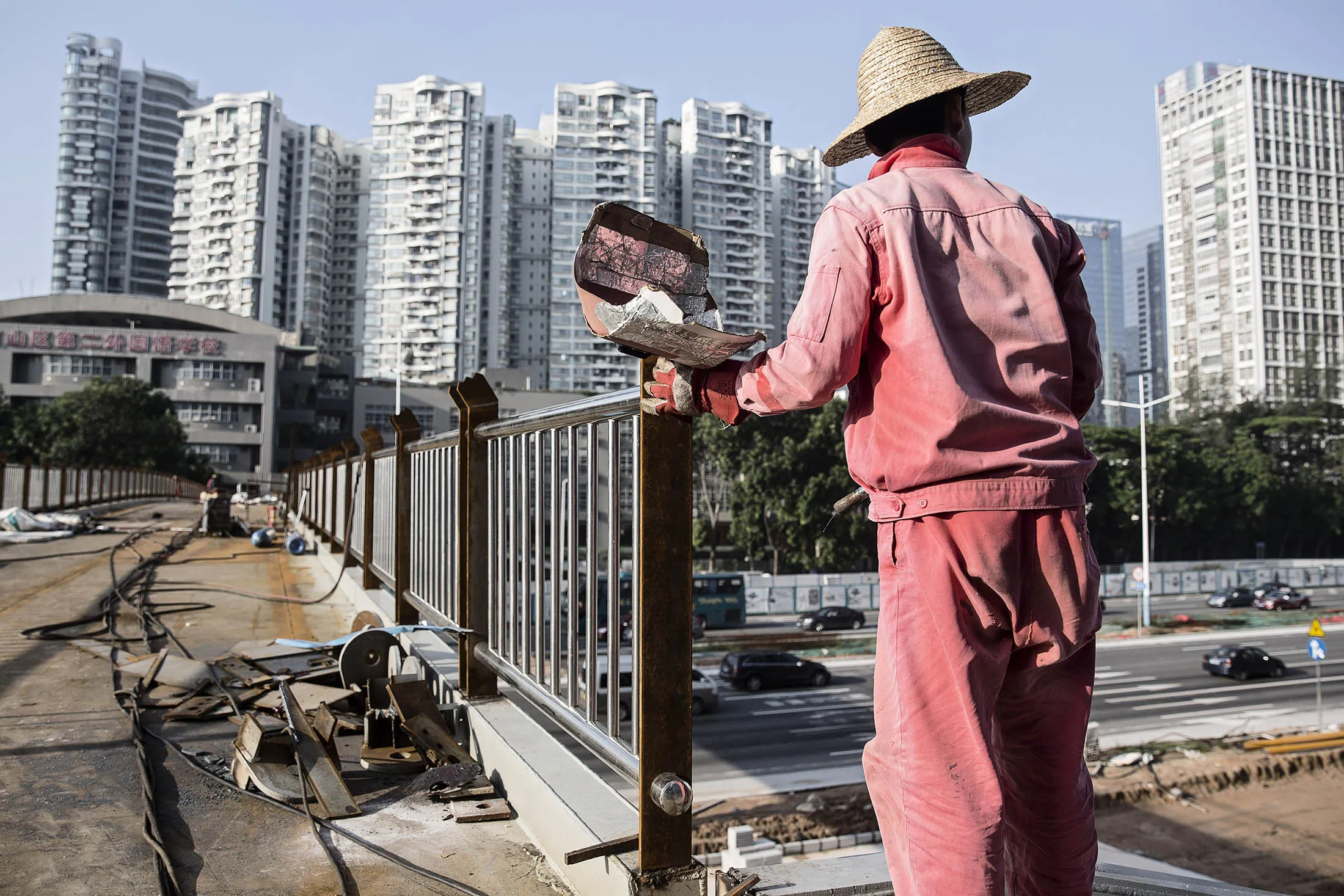 A worker holds a welding mask at a construction site in Shenzhen.
