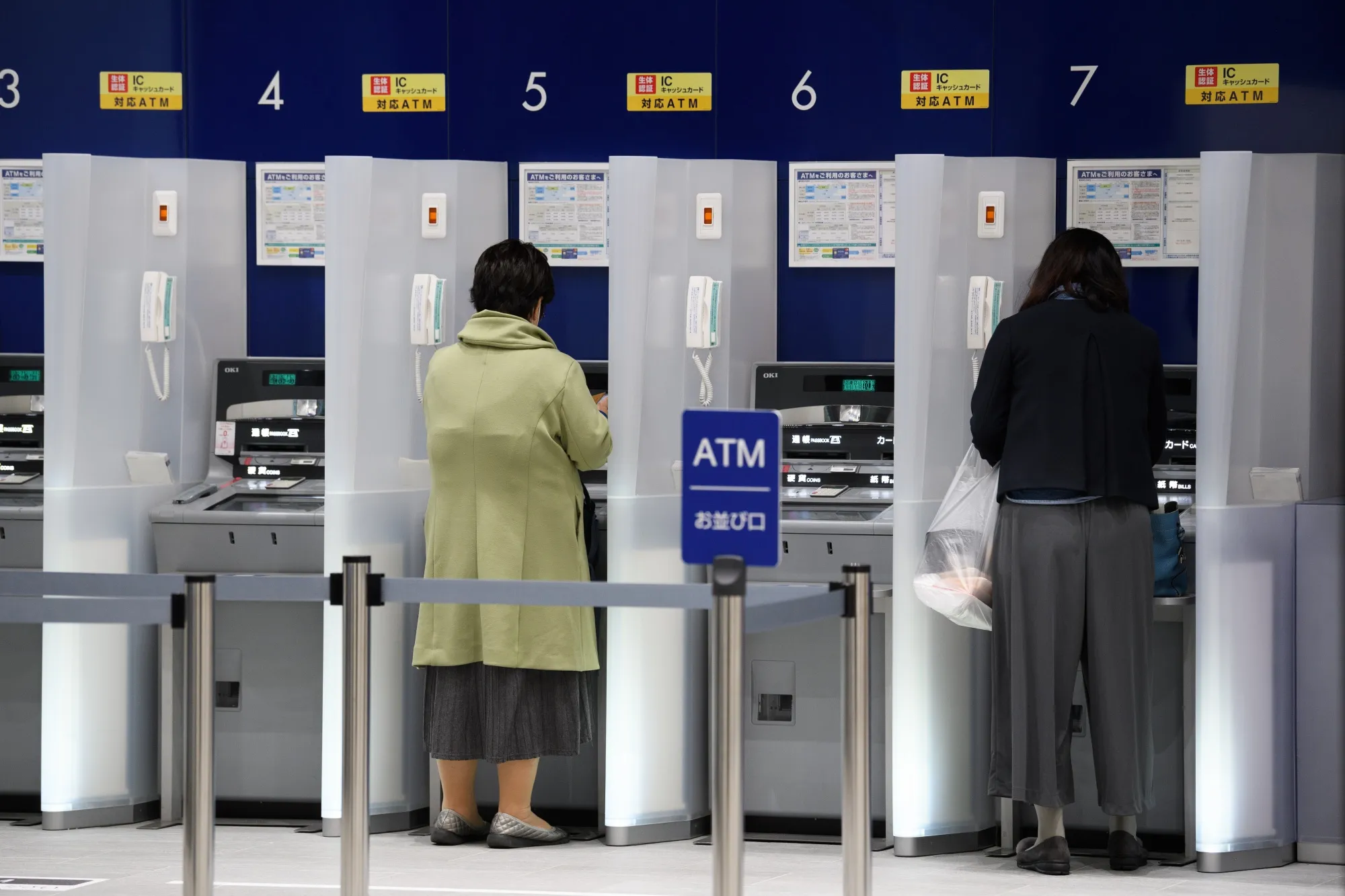 Customers use automated teller machines at a bank in Kawasaki, Kanagawa Prefecture, Japan.