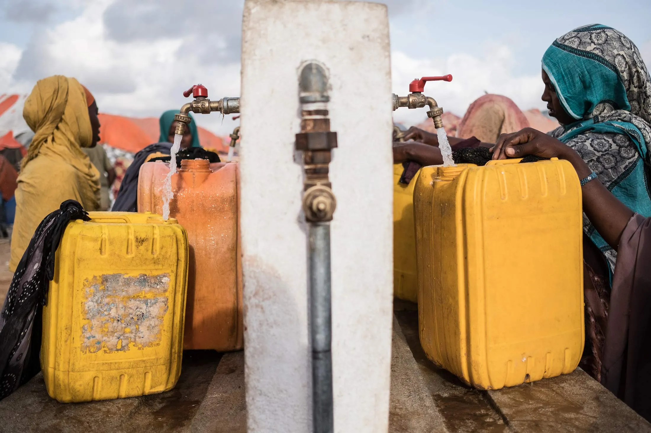 Women filling jerrycans with water from dwell implemented by Polish Humanitarian Action.Somalia in the grip of an unprecedent and devastating food crisis. Drought has caused crops to fail and cattle to die in Somalia causing severe food and water shortages. Brutal conflicts in South Sudan, Yemen and Nigeria and Somalia have driven millions of people from their homes and left millions more in need of emergency food. In Somalia, where cholera outbreaks have killed hundreds of people, the looming famine threatens 6.2 millionmore than half the population. It threatens to bring back the grim reality of 2011, when 260,000 Somalis starved to death. For over two decades, Somalia has been in a state of complex humanitarian crisis, with socio-economic, political and environmental factors leading to widespread conflict, drought, more recently flooding and numerous other recurrent human and natural disasters. In recent days, thousands of Somalis have trekked to Mogadishu desperately searching food and aid. (Photo by
