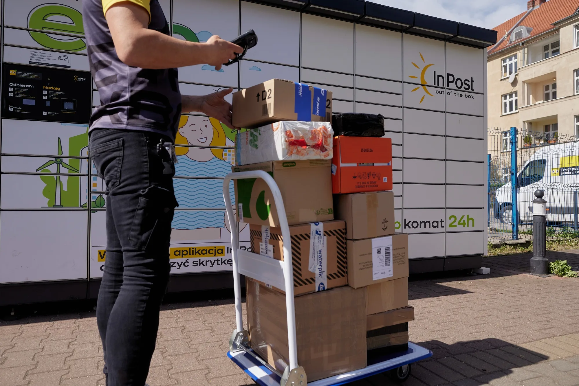 A worker scans parcels at a parcel locker operated by InPost SA in Wroclaw, Poland.