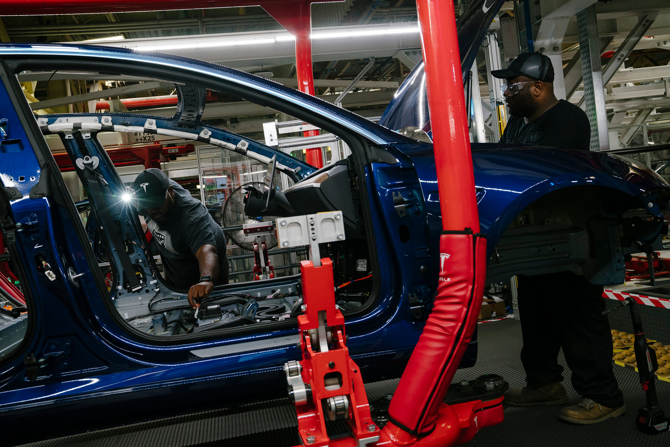 Employees work on a Model 3 at the Tesla factory in Fremont, California, in 2018.