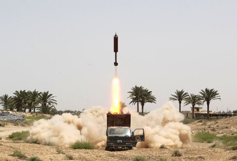 Iraqi pro-government forces and Shiite fighters from the Popular Mobilisation units fire rockets from the village of al-Azraqiyah towards Islamic State (IS) group positions in the city of Fallujah, on June 4, 2016.