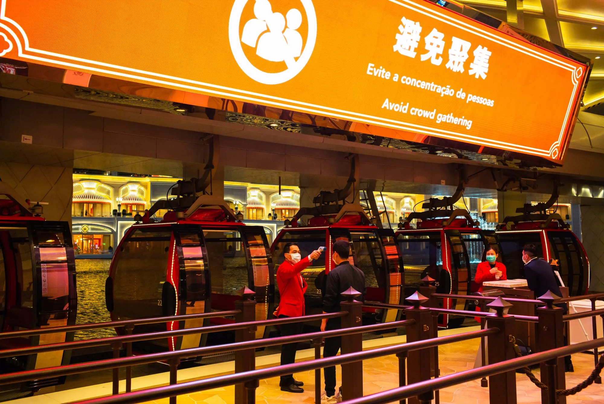 An employee checks a visitor's temperature outsdie the Wynn Palace casino resort in Macau.