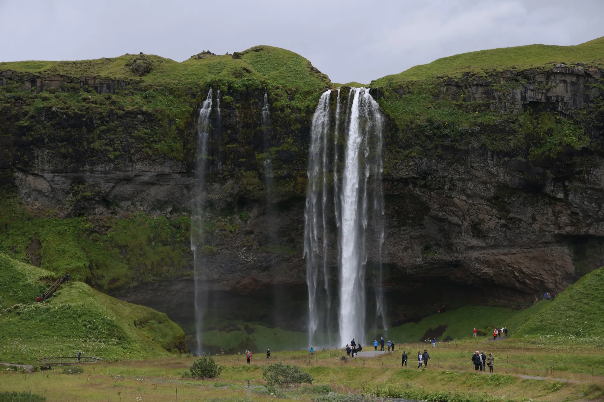 Tourists walk around Seljalandsfoss waterfall near Storidalur, Iceland.&nbsp;