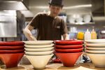 Ramen bowls sit on kitchen counter inside an Ippudo restaurant.
