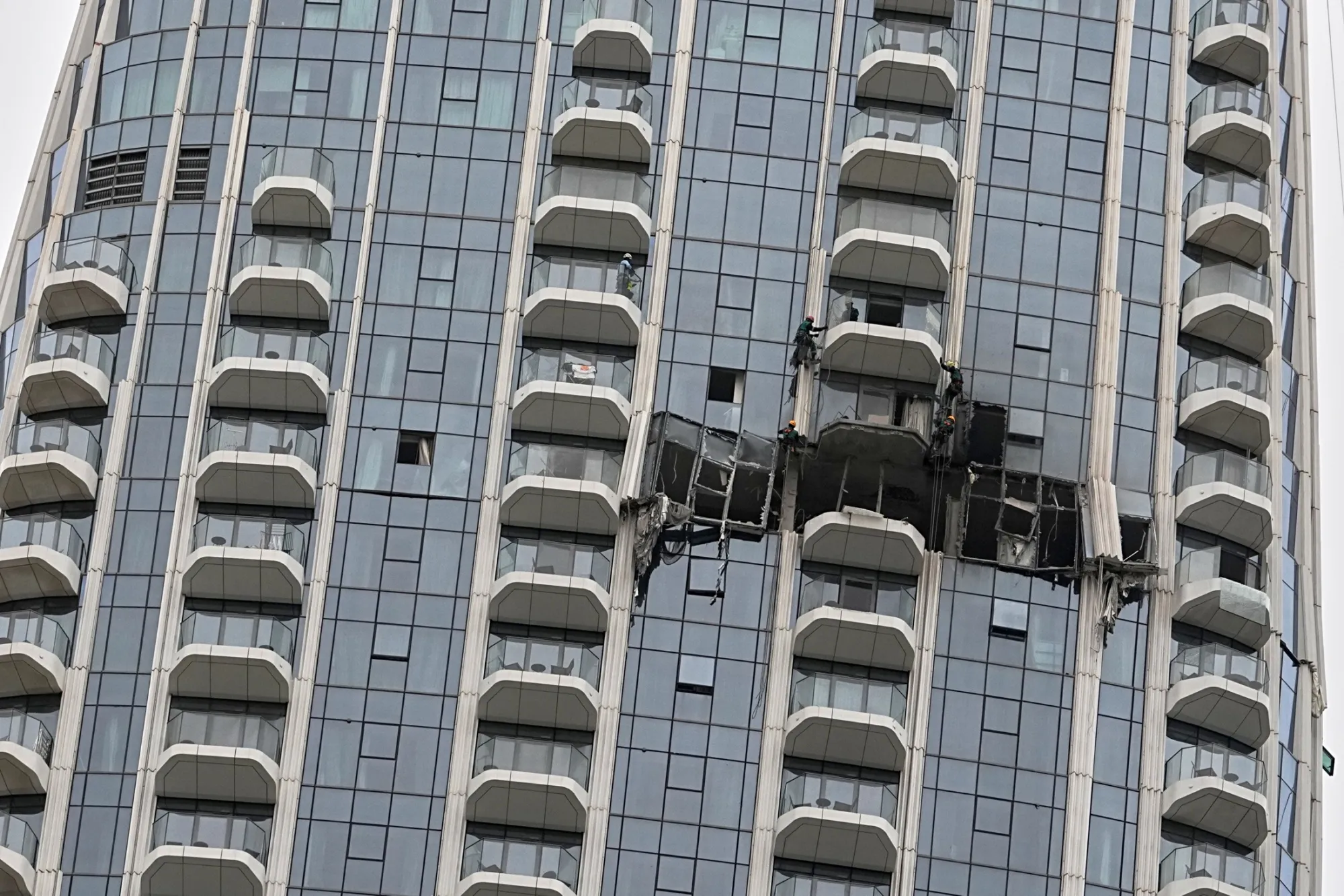 Workers inspect damage to a building in Dubai Creek Harbour, Dubai, on March 12.