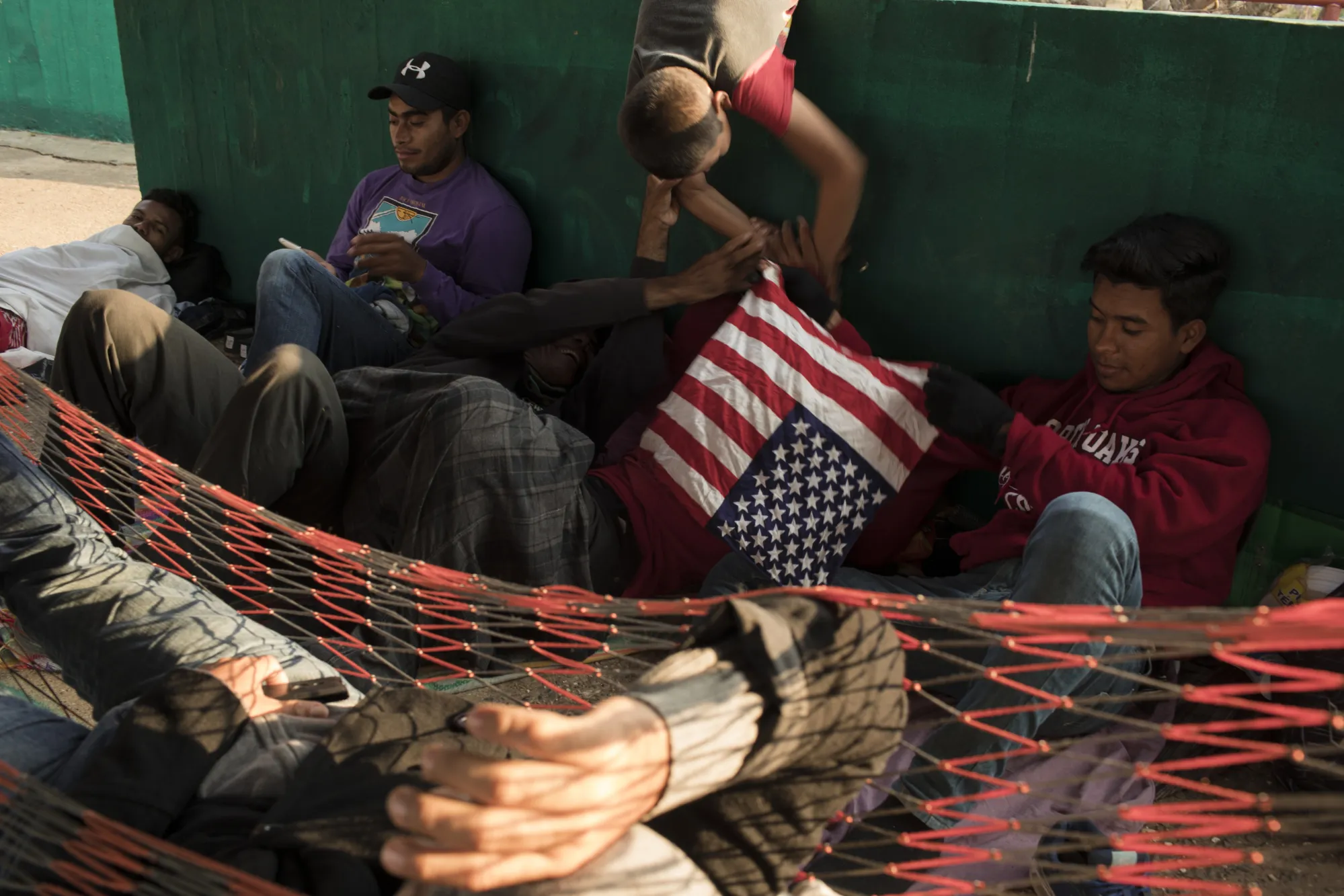A group of Central American refugees and asylum seekers hold an American flag bandanna while taking shelter in the town of Matias Romero, Oaxaca state, Mexico&nbsp;on&nbsp;April 4, 2018.&nbsp;