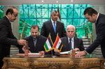 Fatah's Azam al-Ahmad (R)and Saleh al-Aruri (L) of Hamas sign a reconciliation deal at the Egyptian intelligence services headquarters in Cairo on October 12, 2017.