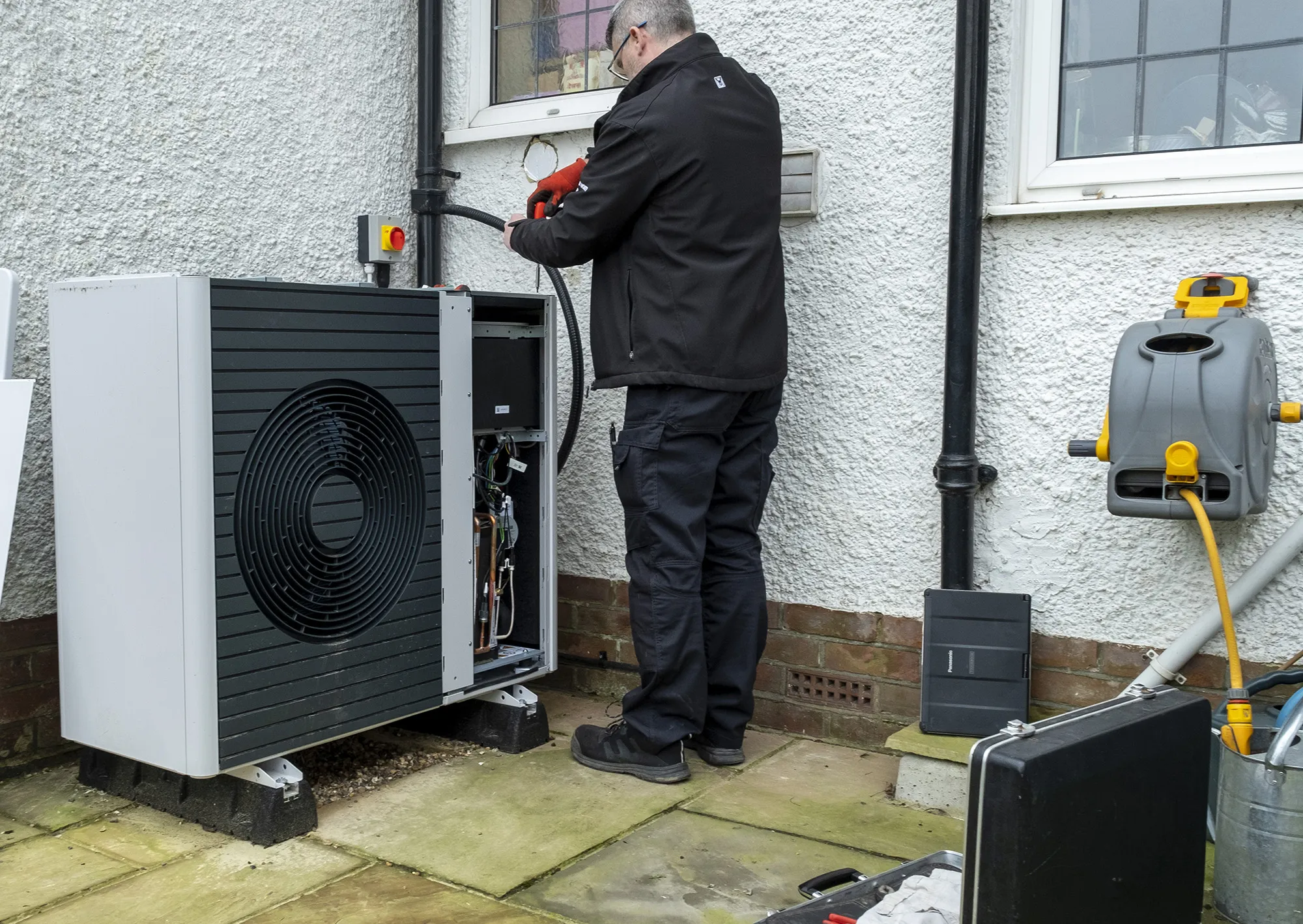An air source heat pump repairman. A collective in Washington state is increasing access to heat pumps for low-income households using a unique approach to financing.