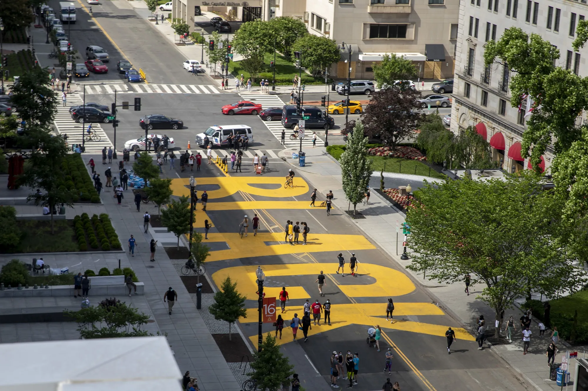 People walk down 16th street after volunteers, with permission from the city, painted "Black Lives Matter" on the street near the White House on June 5.