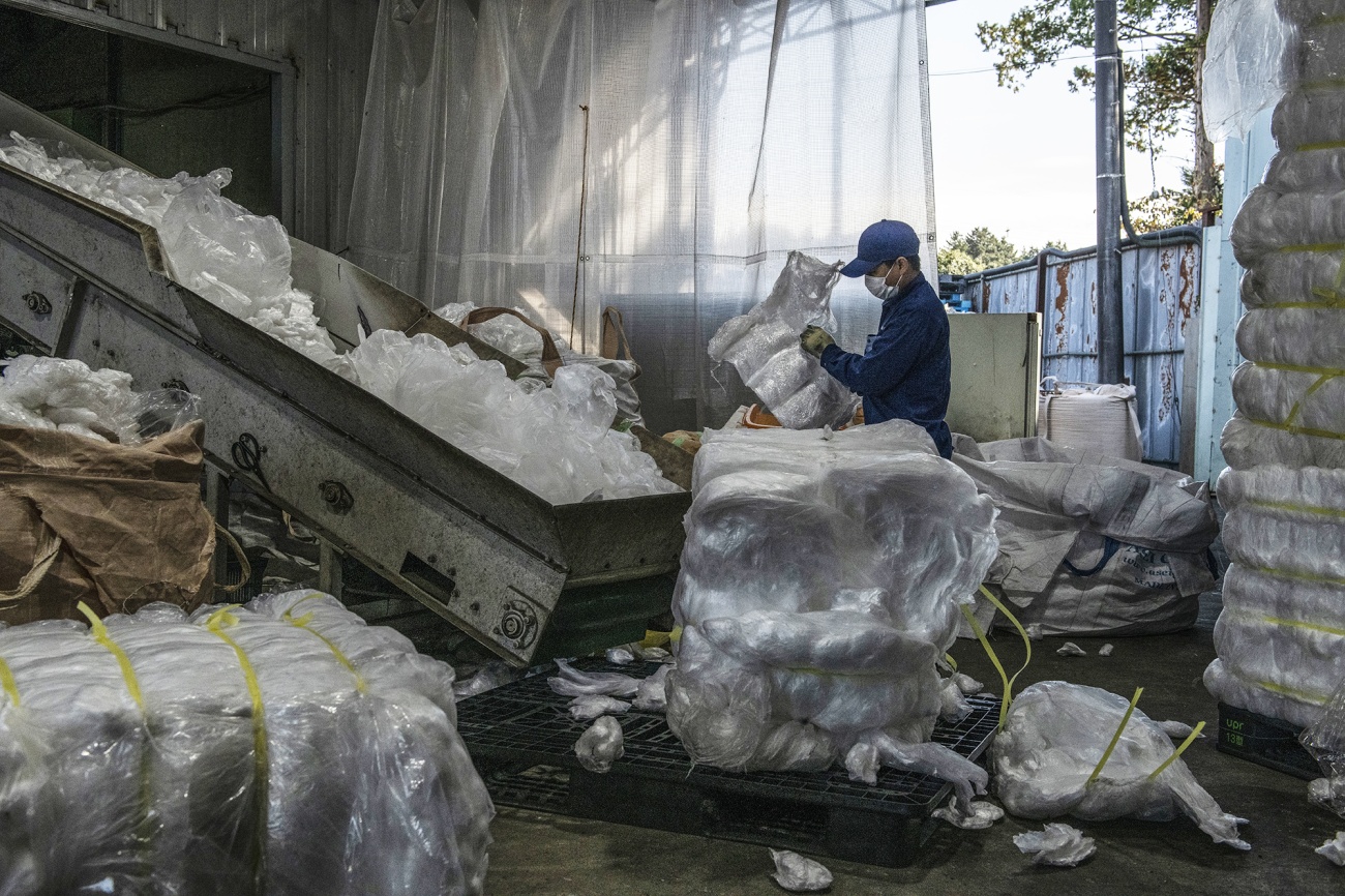 A worker loads plastic bags into a shredding machine to be recycled and turned into pellets in Kasama, Japan. Photographer: Carl Court/Getty Images