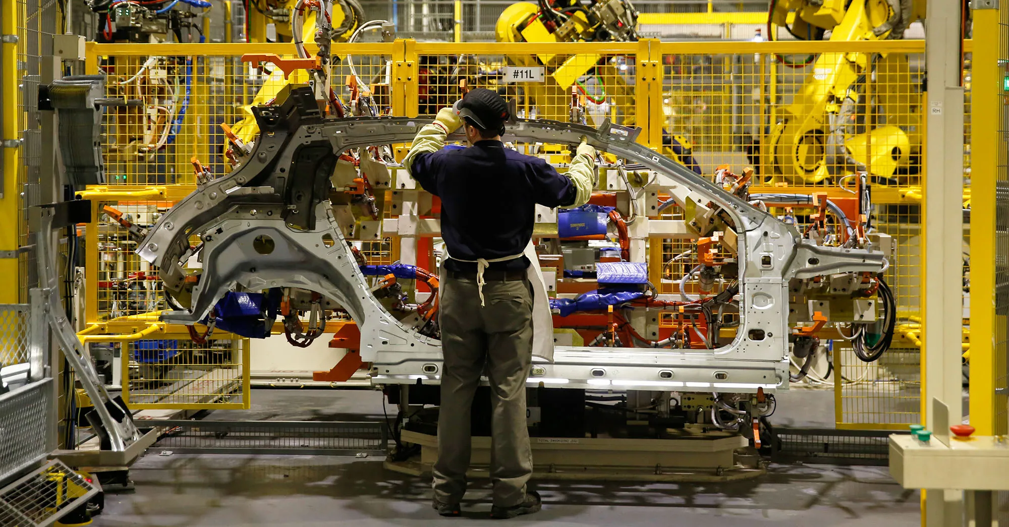 An employee handles a side panel of an&nbsp;automobile on the production line at the Nissan Motor Co. production plant in Sunderland, U.K.