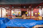 A customer buys fresh produce from a grocery stall at the Ballaro open-air market in Palermo, Italy.