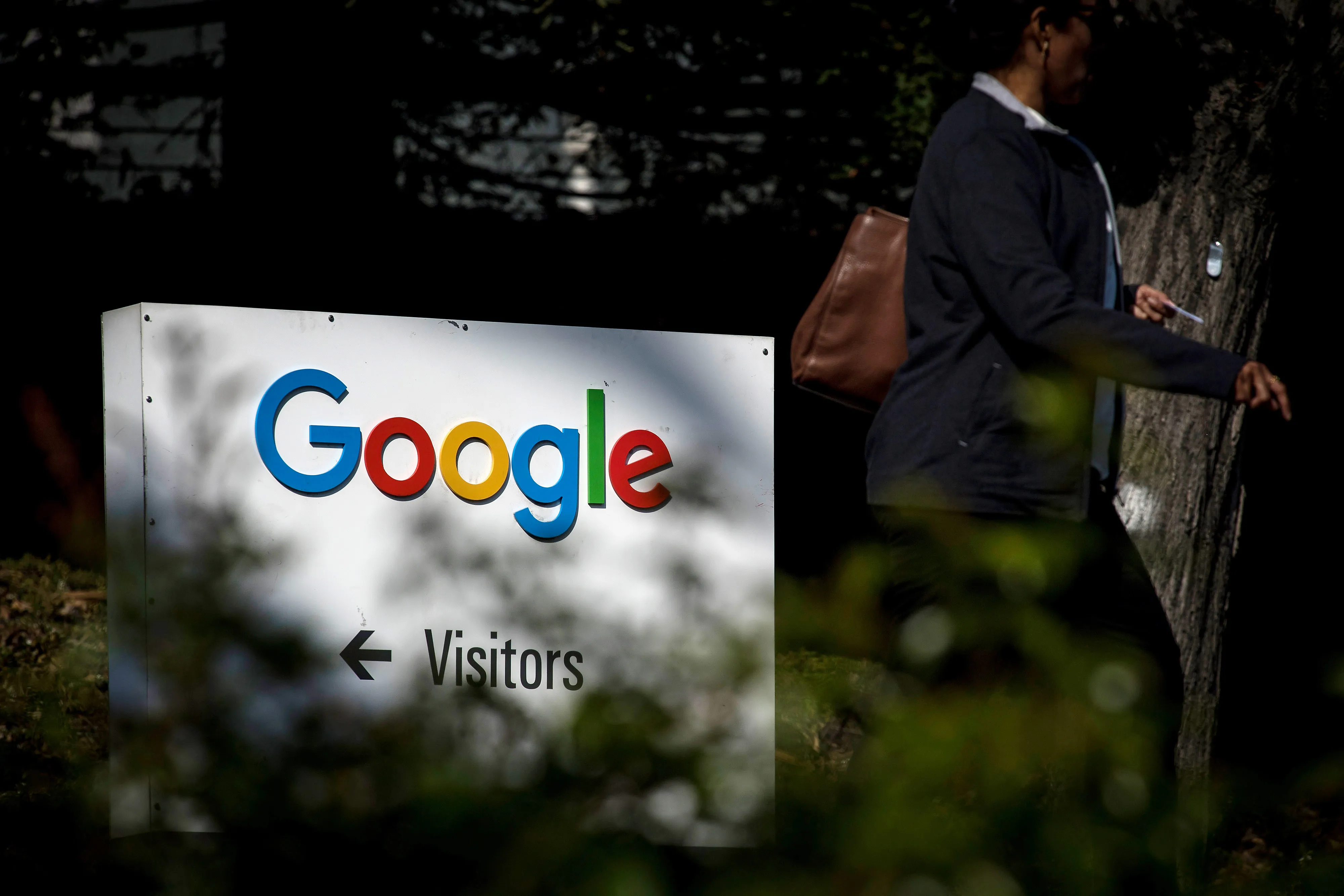 A pedestrian walks past signage at Google headquarters in Mountain View, California.