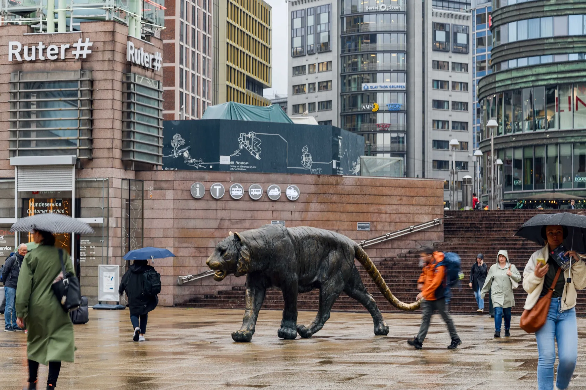 Commuters pass "The Tiger" statue near Oslo central station in Oslo.