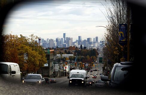 Traffic and buildings are reflected in the rear view mirror of a vehicle in Vancouver.