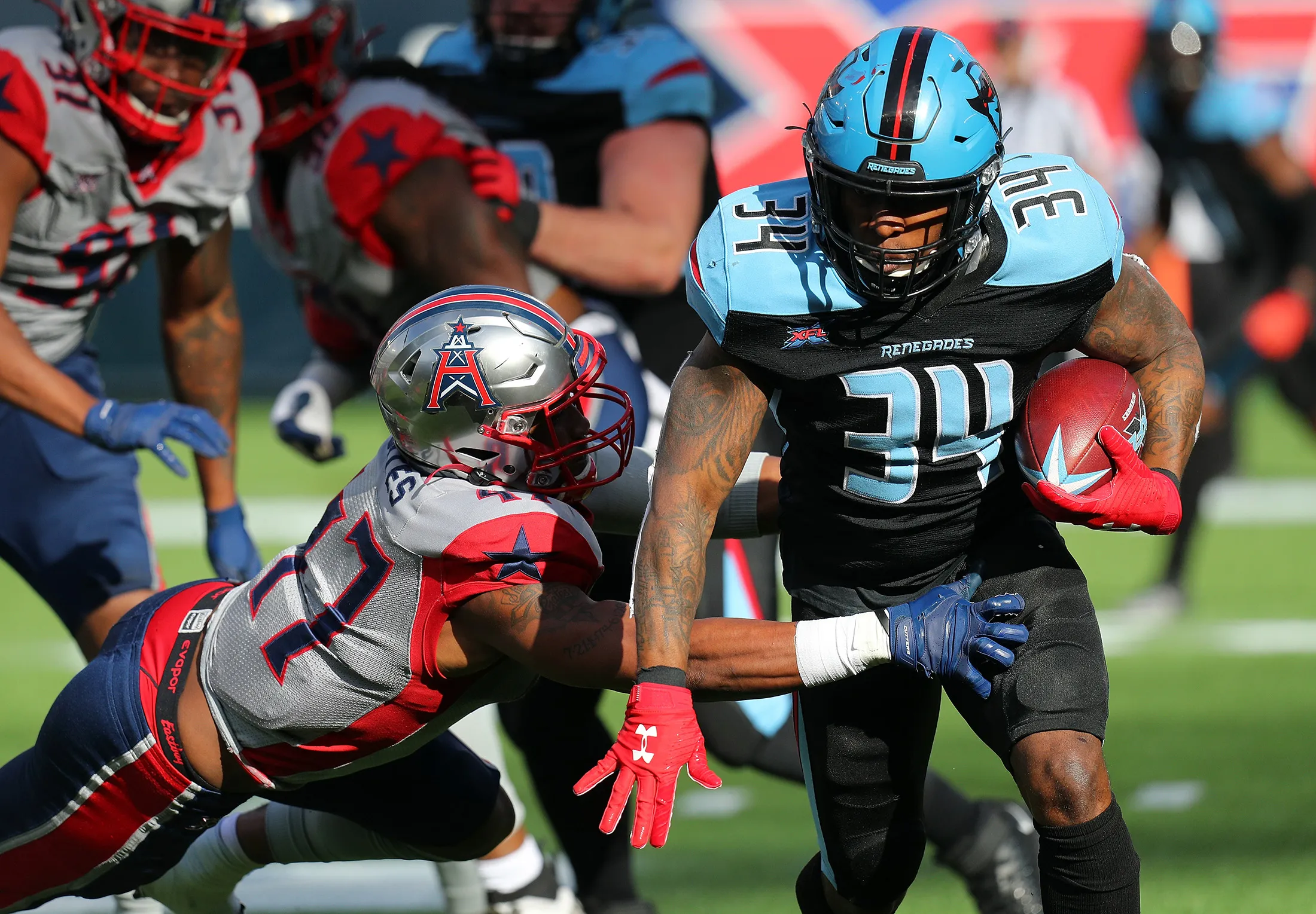DeMarquis Gates&nbsp;of the Houston Roughnecks tries to stop the run by Cameron Artis-Payne of the Dallas Renegades during an XFL football game on March 1, 2020.
