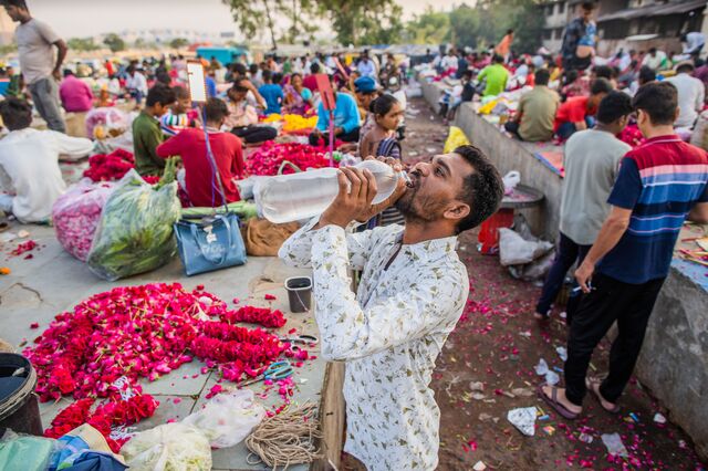 A vendor takes a water break at a wholesale flower market in Ahemdabad in Gujarat, India, on Friday, May 5, 2023. Photographer: Prashanth Vishwanathan/Bloomberg