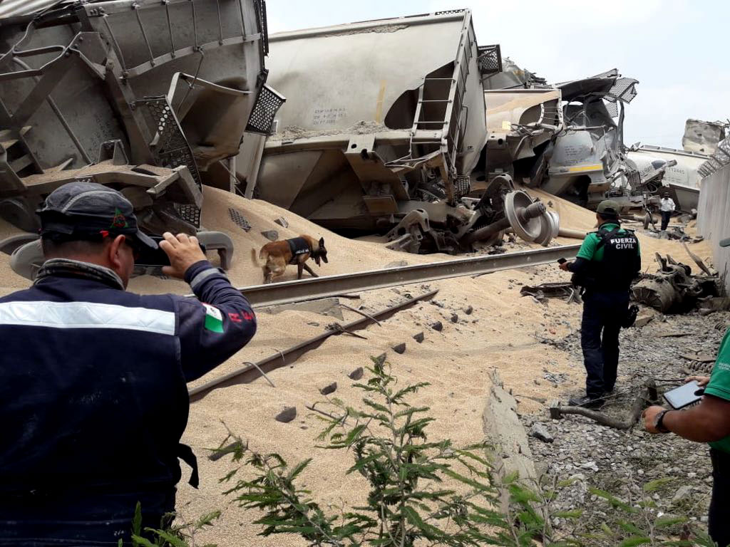 Police inspect a derailed train after it was looted.

&nbsp;